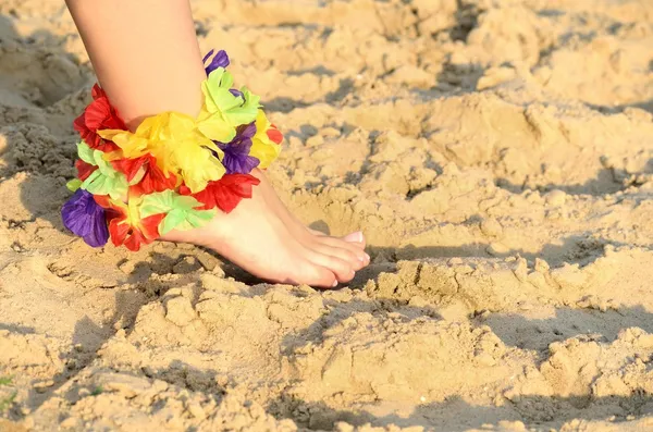 Foot on sand with flowers — Stock Photo, Image