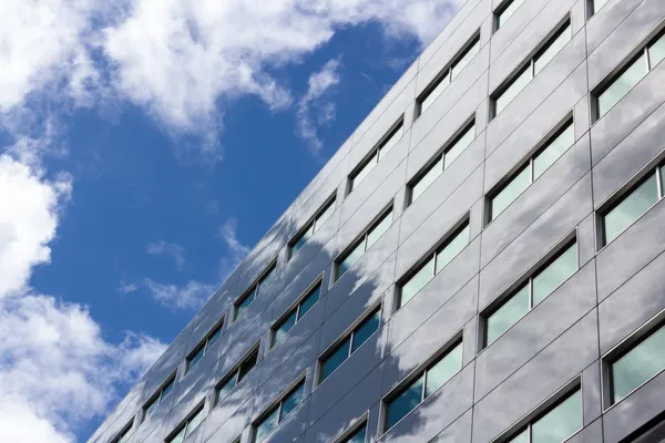 Edifício de escritórios reflete o céu nublado — Fotografia de Stock