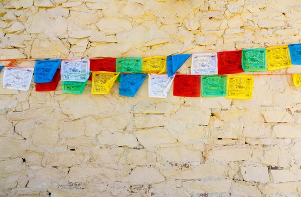 Bandeiras budistas de oração tibetana contra a parede — Fotografia de Stock