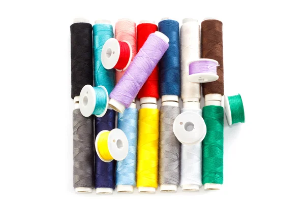 Verschillende veelkleurige spoelkokers en spoelen voorzien van naaigarens — Stockfoto