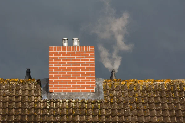 Крыша и дымоход на фоне плохой погоды — стоковое фото
