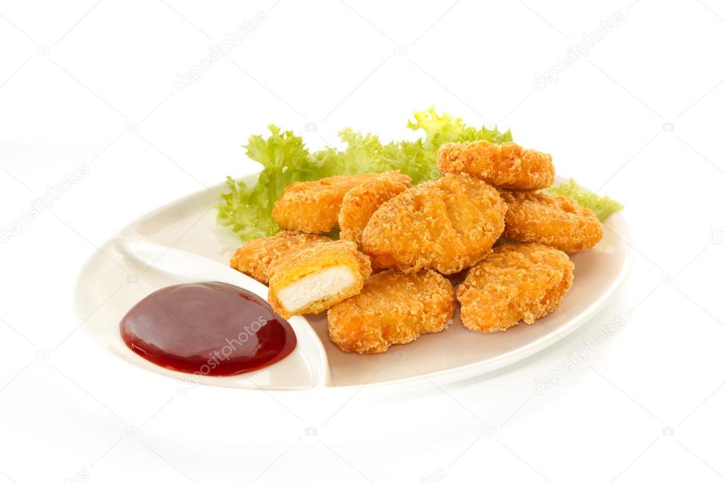 Plate of nuggets with dip sauce, one nugget cut