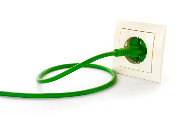 绿色电源插头插入电源插座 免版税图库照片