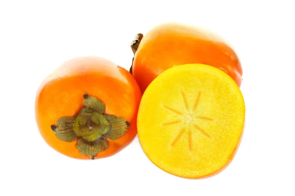 Three kaki fruits, one cut in half — Stock Photo, Image