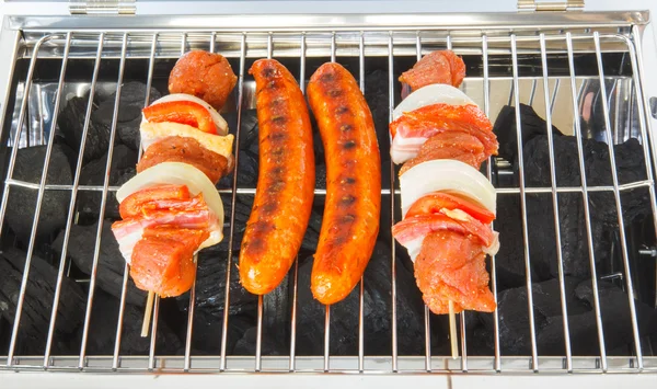 Sausages and meat skewers on the barbecue — Stock Photo, Image