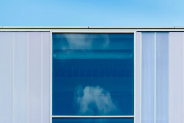 Weerspiegeling van wolken in blauwe venster — Stockfoto