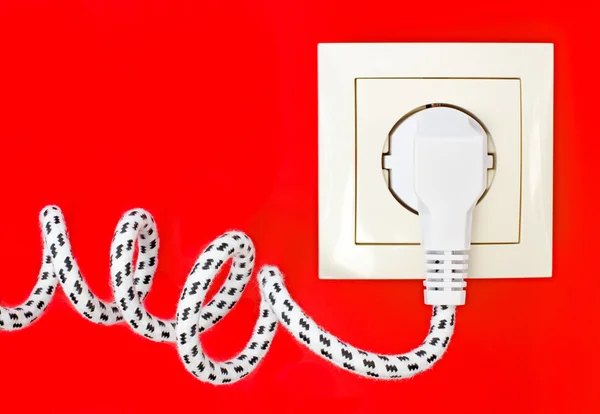 Cable de alimentación y toma de corriente sobre fondo rojo — Foto de Stock