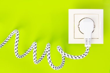 Power plug gets green energy from power socket clipart