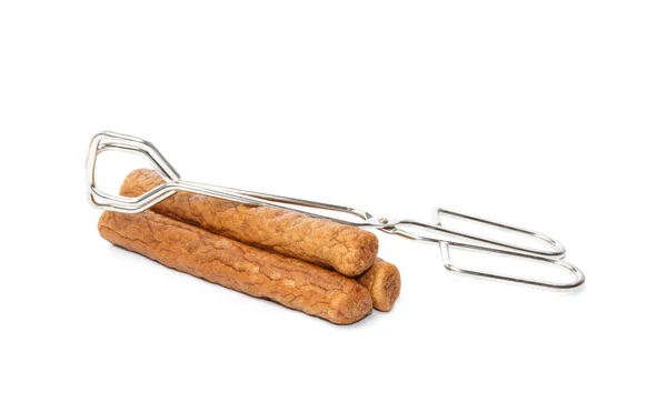 Three frikandellen with frying tongs — Stock Photo, Image