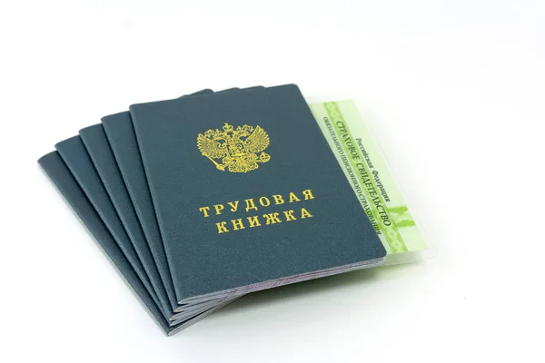 Översättning från ryska - Arbetarbok, Försäkring Pension Certificate. En bunt dokument. Arbetsbok, anställningsprotokoll, ett dokument för registrering av arbetslivserfarenhet. Stockbild