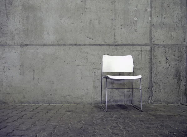 White chair and concrete wall — Stock Photo, Image