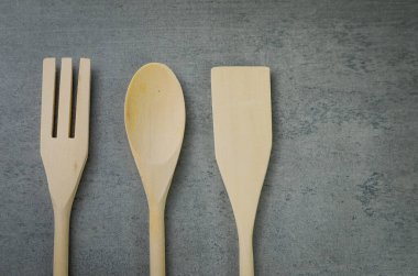 Gri arkaplanda ahşap çatal bıçak takımı.