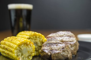 Lezzetli fileminyon. Kavrulmuş mısır ve bir bardak birayla yakın plan..