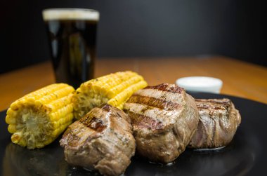Lezzetli fileminyon. Kavrulmuş mısır ve bir bardak birayla yakın plan..