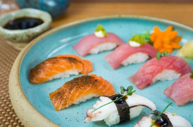 Çok güzel dekore edilmiş bir tabakta çeşitli özel ton balığı ve somon nigiri suşisi..