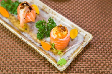 Farklı çeşnilerle süslenmiş zarif suşi tabağı. Seçici odak.