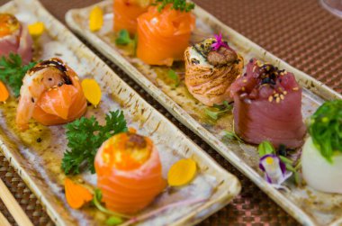 Farklı çeşnilerle süslenmiş zarif suşi tabağı. Seçici odak.