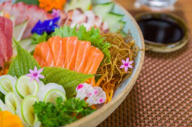 Farklı aromalı Sashimi suşisi, somon balığı, ton balığı, halibut ve yanmış somon ile süslenmiş bir tabak. Seçici odak.