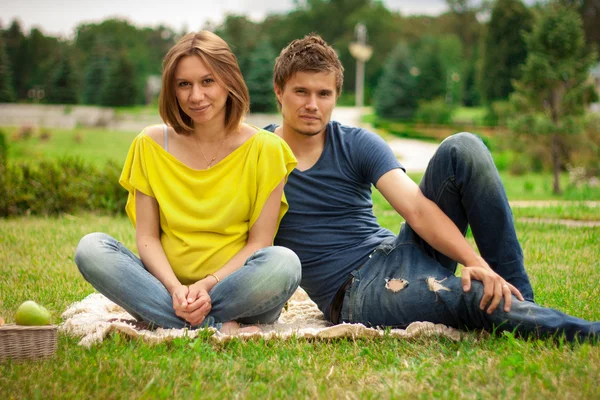 Young pretty pregnant woman with young man outdoor in the park — Stock Photo, Image