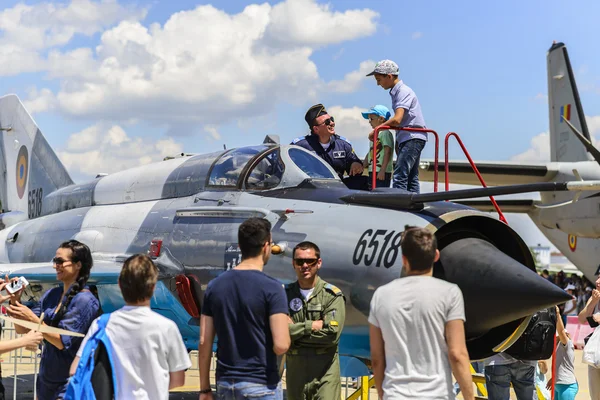 Piloto de combate describiendo su avión a los niños —  Fotos de Stock