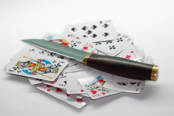 Knife lying on a deck of cards