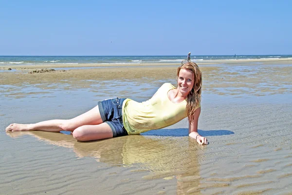 Unga blonda kvinnan ligga i vatten från Nordsjön — Stockfoto