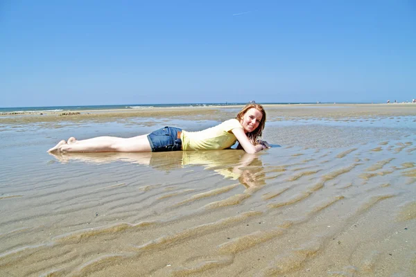 Mujer rubia joven acostada en el agua desde el mar del norte — Foto de Stock