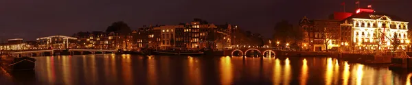 Amsterdam panorama s thiny bridge v noci v Nizozemsku — Stock fotografie