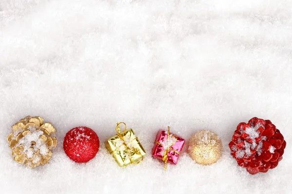 Christmas ornaments and presents on a snowy background — Stock Photo, Image