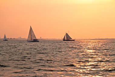 Hollanda 'daki IJsselmeer' de gün batımında yelken açmak.