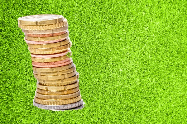 Hromada mincí v zelené trávě — Stock fotografie
