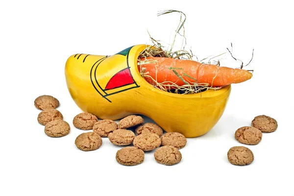 Wooden clog with straw, gingernuts and carrot — Stock Photo, Image