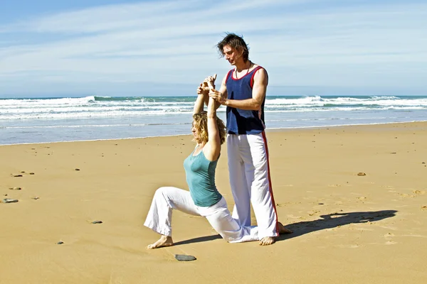 Profesora de Yoga enseña yoga a los estudiantes en la playa —  Fotos de Stock