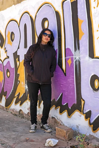 Žena v černém na cihlovou zeď graffiti — Stock fotografie