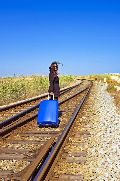 Молода жінка з валізою на залізничній колії — стокове фото