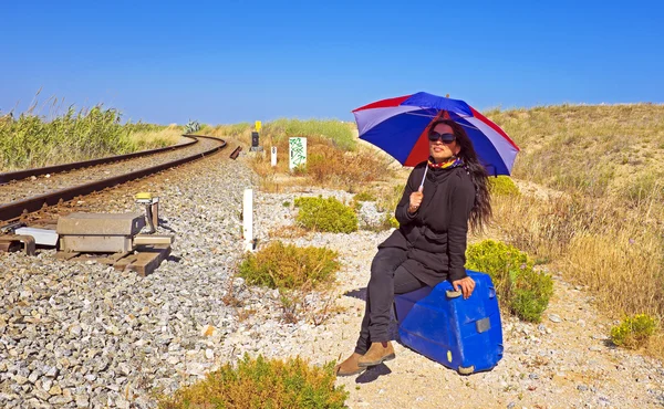 Jonge vrouw met haar koffer te wachten op een track-spoorweg — Stockfoto