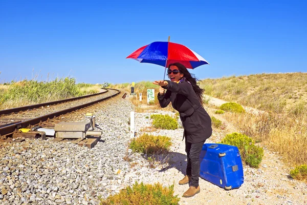 鉄道トラックで待っている彼女のスーツケースを持つ若い女 — ストック写真