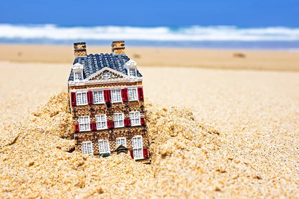 Casa a desaparecer na areia. Conceito para imóveis em crisi — Fotografia de Stock