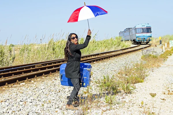 Young desperate woman at a passing train — Stock Photo, Image