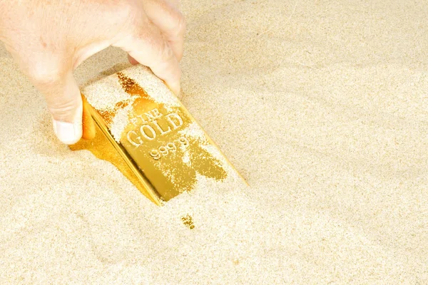 Creuser une barre d'or dans le sable — Photo