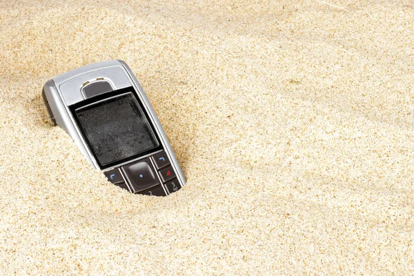 Téléphone portable dans le sable — Photo