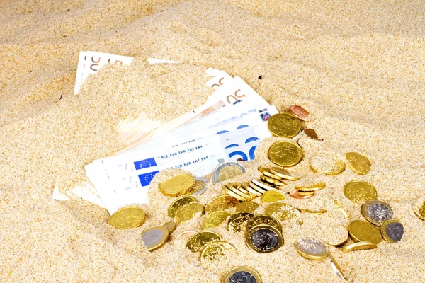 Notas e moedas de euro na areia — Fotografia de Stock