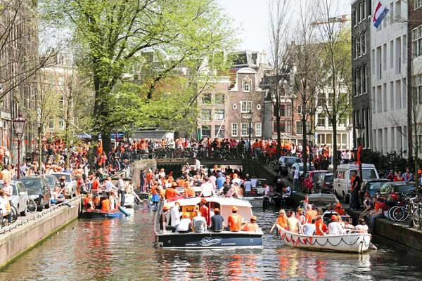 AMSTERDÃO - 30 DE ABRIL: Canais de Amsterdã cheios de barcos e pessoas — Fotografia de Stock