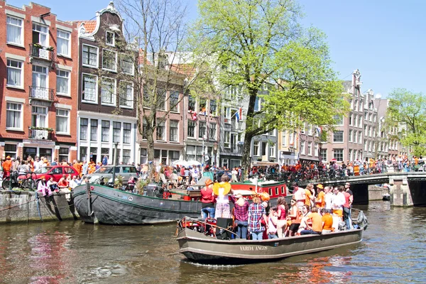 AMSTERDÃO - 30 DE ABRIL: Canais de Amsterdã cheios de barcos e pessoas — Fotografia de Stock