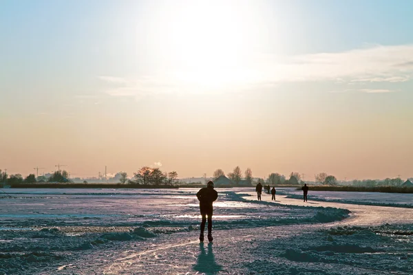 Patinação no gelo no campo a partir dos Países Baixos ao pôr do sol — Fotografia de Stock