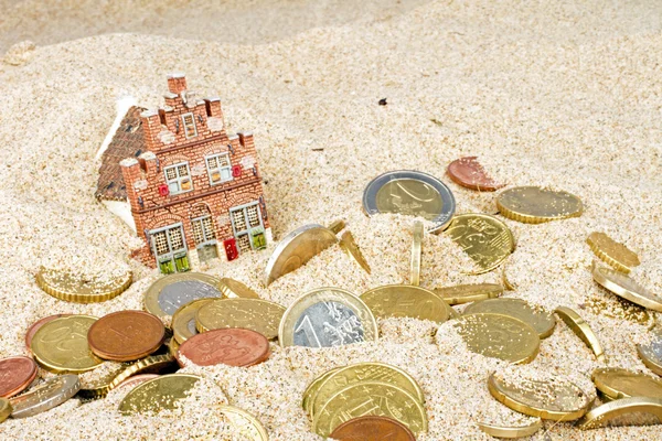 Haus und Euromünzen verschwinden im Sand — Stockfoto