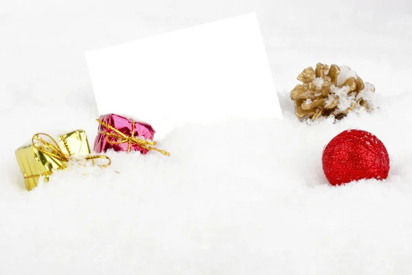Tyhjä valkoinen kortti joulukoristeita lumessa — kuvapankkivalokuva