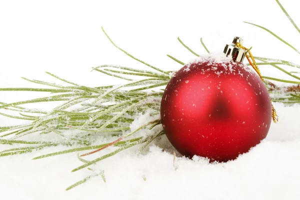 Red christmas ball with fir in the snow — Stock Photo, Image