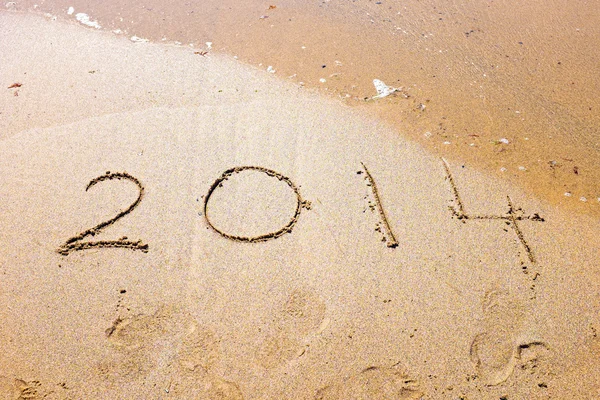 Gott nytt år, 2014 skriven i sanden på stranden — Stockfoto