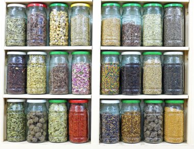 assortment of glass jars on shelves in herbalist shop in marrake clipart